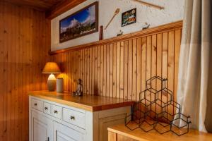 a room with a wooden wall with a table and a lamp at Rudnica House in Bohinj