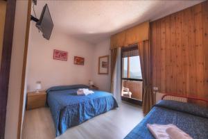1 dormitorio con 2 camas y ventana en Hotel Sancamillo, en Dimaro