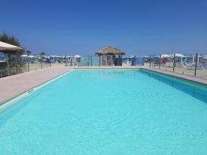 a large blue swimming pool next to a beach at Appartamento " Al ponte degli Sbirri " centro Comacchio in Comacchio
