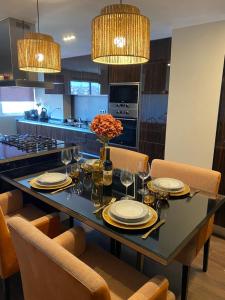 a dining room table with plates and glasses and a vase of flowers at A Casa do Chapéu de Palha in Setúbal