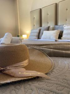 two beds with white pillows and a hat on the floor at A Casa do Chapéu de Palha in Setúbal