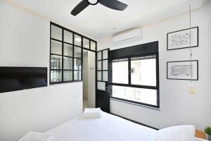 1 dormitorio con 1 cama y ventilador de techo en Luna Moona by HolyGuest, en Tel Aviv