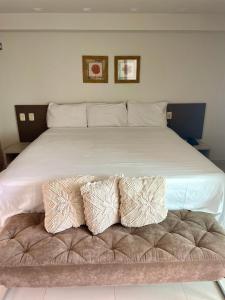 ein großes weißes Bett mit zwei Kissen darauf in der Unterkunft Tabatinga Residence Flat Pé na Areia I in Conde