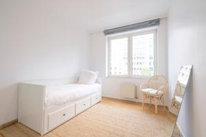 um quarto branco com uma cama e uma janela em Lumineux Appartement 2 chambres entre le Châtelain et l'Avenue Louise em Bruxelas