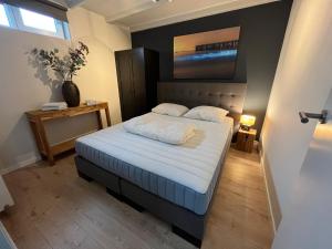 1 dormitorio pequeño con 1 cama con sábanas blancas en Vakantiehuis Zeevonk Koudekerke, en Koudekerke