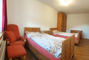 a bedroom with two bunk beds and a chair at Privatzimmer Fasser in Müstair- Zentrale Lage in Müstair