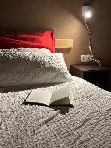 un libro sentado en la parte superior de una cama con una lámpara en Bel'vue, en Lienz