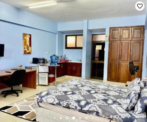 a bedroom with a bed and a desk and a computer at Queens Rentals - Studio Apartments - Village Walkway - Masaki - Dar es Salaam in Dar es Salaam