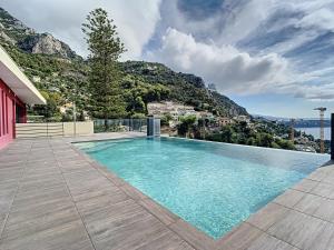 a swimming pool with a mountain in the background at Great studio with a sea view and parking in 400 meters from Monaco in Beausoleil