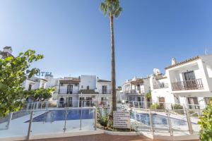 rząd białych budynków z palmą w obiekcie Canovas Nerja - Nueva Nerja - Pueblo Andaluz 94 w mieście Nerja