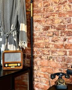 um rádio velho sentado numa mesa ao lado de uma parede de tijolos em RUZ Hotels em Istambul