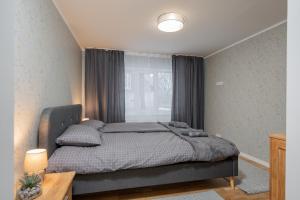 a bedroom with a bed and a window at Loode lux with sauna in Tartu