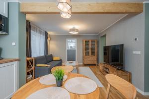 uma sala de estar com uma mesa e cadeiras e um sofá em Loode lux with sauna em Tartu