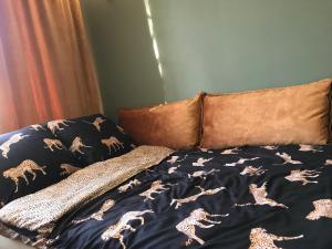 - un lit avec une couverture avec des chevaux dans l'établissement Apartament Drochaczyński, à Ostrów Wielkopolski