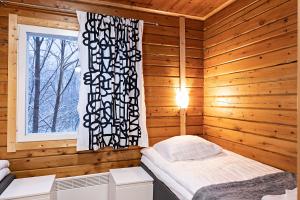 1 dormitorio con 1 cama en una habitación de madera en Arctic River Resort, en Ivalo