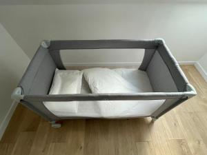 a bed frame with two pillows on a floor at Charmant 3 pièces gare de Creil in Creil