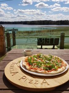 une pizza assise sur une table en bois dans l'établissement Namelis su ofuro vonia prie Plateliu ežero, à Medsėdžių