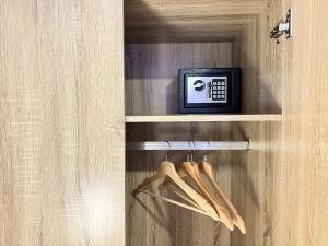 a shelf with a clock and hangers in a room at Spazios Apart Hotel Reñaca in Viña del Mar