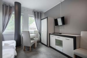 Cette chambre comprend une chambre avec une table et un miroir. dans l'établissement Keja Aparts - 04 Gdynia Centrum, à Gdynia
