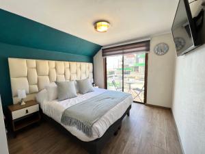 a bedroom with a large bed with a blue wall at Spazios Apart Hotel Reñaca in Viña del Mar