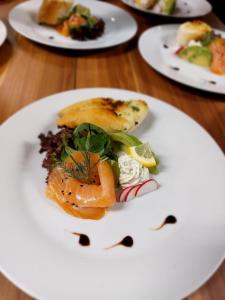 a white plate of food on a wooden table at LONDON Boutique hotel & Restaurant in Trnava