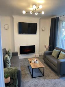 a living room with two couches and a fire place at STOP at Talbot Road! in Port Talbot