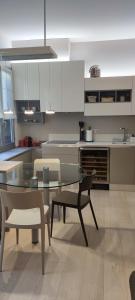 a kitchen with a glass table and chairs at BB Art Wine & Suite in Imola +19 photos