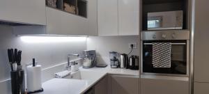 a kitchen with white cabinets and a black and white appliance at BB Art Wine & Suite in Imola