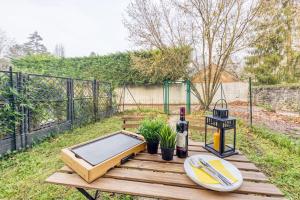 una mesa de madera con un plato de comida. en Cocoon - Jardin - Boite à clé - Wi-Fi, en Baulne