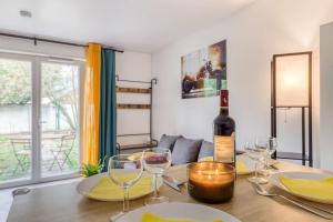 uma garrafa de vinho sentada numa mesa com copos em Cocoon - Jardin - Boite à clé - Wi-Fi em Baulne