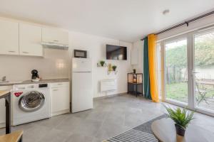 cocina con lavadora y ventana en Cocoon - Jardin - Boite à clé - Wi-Fi, en Baulne 5 fotos más