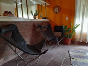 2 sillas en una sala de estar con paredes de color naranja en Alojamiento Passiflora I en Villa Elisa