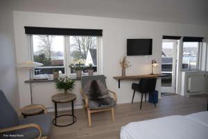 a living room with a bed and a desk with a television at Færgekroen Hadsund in Hadsund