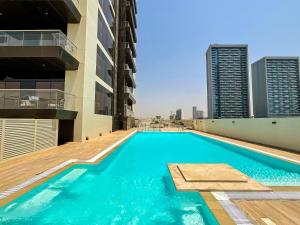 una piscina en la azotea de un edificio en WelHome - Evergreen Apartment Amidst Vibrant JVC With Pool, en Dubái