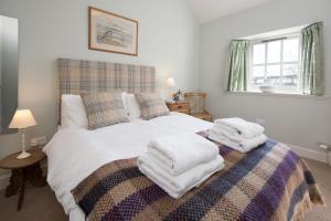 a bedroom with a bed with towels on it at The Heritage Cottage in Swinton