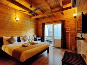 a bedroom with a large bed in a wooden room at La Vie Woods- couples/families only in Calangute