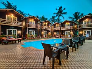 a resort with a pool and tables and chairs at La Vie Woods- couples/families only in Calangute