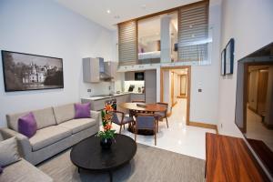 a living room with a couch and a table at Sanctum Belsize Road in London