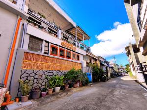a building with plants on the side of a street at Evan's Homestay in Basco