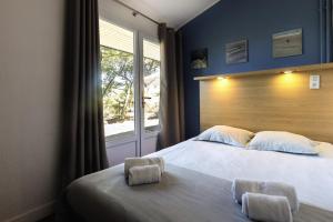 um quarto com uma cama grande e uma janela em Belambra Clubs Capbreton - Les Vignes em Capbreton