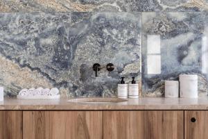 a bathroom with a sink and a marble wall at Kimpton Aysla Mallorca by IHG in Santa Ponsa