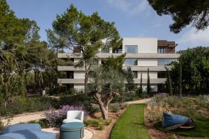 an apartment building with a garden in front of it at Kimpton Aysla Mallorca by IHG in Santa Ponsa