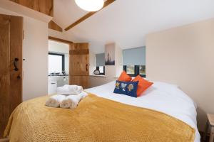 a bedroom with a bed with orange and blue pillows at Springfield Linney in Marwood