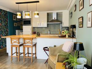 a kitchen and living room with a table and a couch at La Corneille en Mer in Ostend