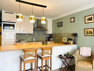a kitchen with a counter and chairs in a room at La Corneille en Mer in Ostend +10 photos