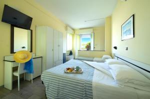 Un dormitorio con una cama con una bandeja de fruta. en Hotel Baltic, en Cesenatico