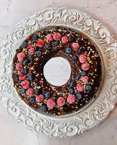a chocolate cake with berries on a plate at Hotel Morri in Bellaria-Igea Marina