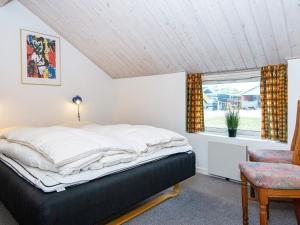 a bedroom with a bed and a window at Four-Bedroom Holiday home in Hemmet 14 in Falen