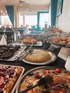 a table with many different types of cakes and pastries at Hotel Morri in Bellaria-Igea Marina