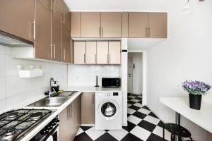 a kitchen with a washer and a sink and a washing machine at Superior Metro Centrum Apartment in Warsaw